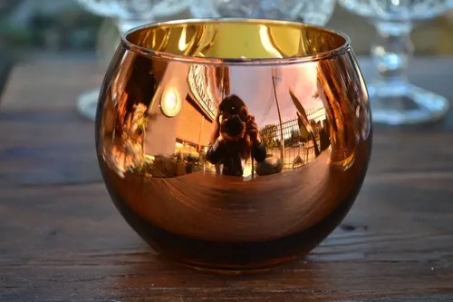 Shiny rose gold-colored round glass vase